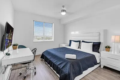 a bedroom with a bed and a desk and a computer at Amazing 2 Bedroom Unit In Doral Miami With Free Parking in Hialeah Gardens