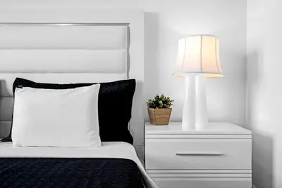 a white bed with a white lamp and a white dresser at Amazing 2 Bedroom Unit In Doral Miami With Free Parking in Hialeah Gardens