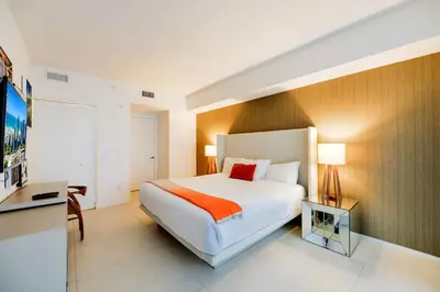 a hotel room with a bed and a television at Ocean & City Views l Luxury Beachfront Condo in Hollywood