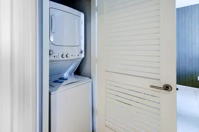 a laundry room with a washer and dryer next to a door at Ocean & City Views l Luxury Beachfront Condo in Hollywood