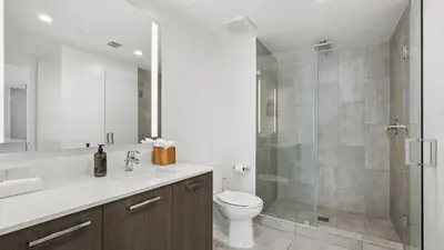 a bathroom with a toilet and a glass shower at Sentral Alea Miami in Miami