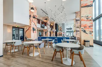 a restaurant with tables and chairs in a building at Sentral Alea Miami in Miami