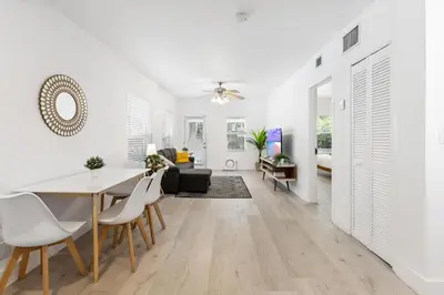 a dining room and living room with white walls and a table and chairs at Dreamy 1-bedroom apt walking distance to Las Olas in Fort Lauderdale