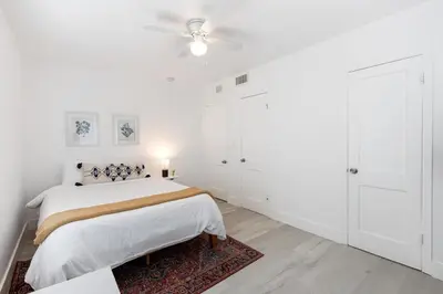 a white bedroom with a bed and a ceiling fan at Charming 2 Bedroom Apartment in Victoria Park in Fort Lauderdale