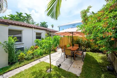 a patio with a table and chairs and an umbrella at Beautiful And Comfortable Apt in Victoria Park in Fort Lauderdale