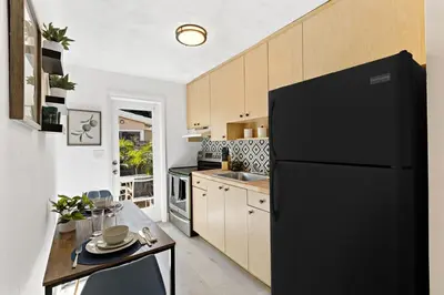 a kitchen with a black refrigerator and a table at Lovely Rental Unit with free Parking on Premises in Fort Lauderdale