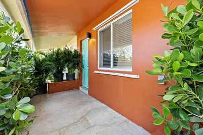 an orange house with a window and plants at Lovely Rental Unit with free Parking on Premises in Fort Lauderdale