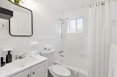 a white bathroom with a toilet and a sink at Lovely Rental Unit with free Parking on Premises in Fort Lauderdale
