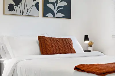 a white bed with a brown blanket on top of it at Lovely Rental Unit with free Parking on Premises in Fort Lauderdale