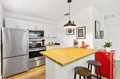 a kitchen with a stainless steel refrigerator and a wooden counter top at Lovely 2 BR condo with free parking on premises in Fort Lauderdale