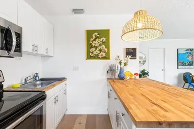 a kitchen with white cabinets and a wooden counter top at Lovely 2 BR condo in Sailboat Bend in Fort Lauderdale