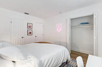 a white bedroom with a white bed and a window at Stylish 2 BR Condo - Free Parking on Premises in Fort Lauderdale