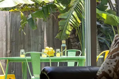 a green table with fruit on it next to a fence at Bright and Spacious 2 BR Apartment in Fort Lauderdale
