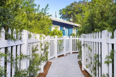 a white fence in front of a house at Bright and Spacious 2 BR Apartment in Fort Lauderdale