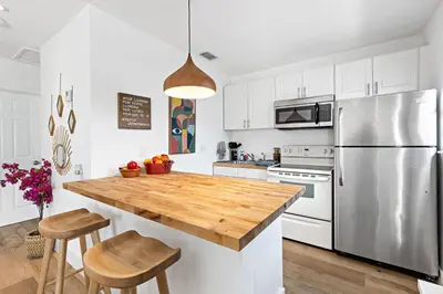 a kitchen with a stainless steel refrigerator and a wooden counter top at Stylish 2 BR condo - close to Riverwalk in Fort Lauderdale