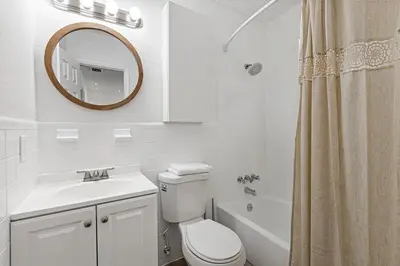 a bathroom with a toilet and a sink and a mirror at Stylish 2 BR condo - close to Riverwalk in Fort Lauderdale