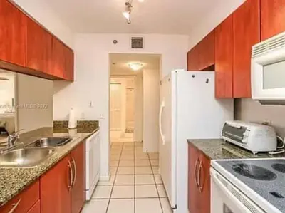 a kitchen with a sink and a white refrigerator at Club at Brickell Bay Bayview Balcony 1BR Free Parking in Miami