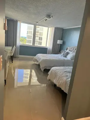 a bedroom with two beds and a reflection in the floor at Entire Condo in Sunny Isles in Sunny Isles Beach