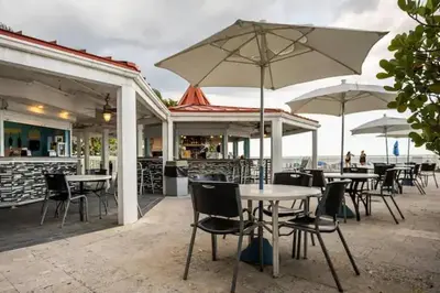 an outdoor patio with tables and chairs and umbrellas at Entire Condo in Sunny Isles in Sunny Isles Beach