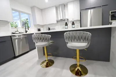 two bar stools in a kitchen with white cabinets at Villa Cristina in Miami in Miami