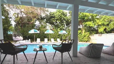 a patio with chairs and a table and a pool at Villa Cristina in Miami in Miami