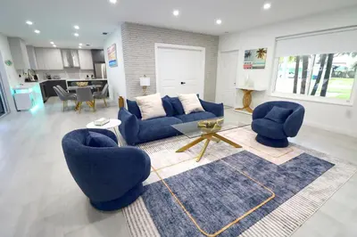 a living room with two blue chairs and a table at Villa Cristina in Miami in Miami