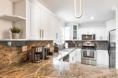 a kitchen with white cabinets and stainless steel appliances at Le Femme Paradise -Htd Pool, Mini Golf, 5 Bedrooms, Jacuzzi, Game Room, BBQ,Pickleball in Miami