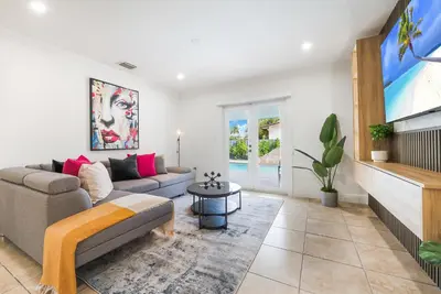 a living room with a couch and a tv at Le Femme Paradise -Htd Pool, Mini Golf, 5 Bedrooms, Jacuzzi, Game Room, BBQ,Pickleball in Miami