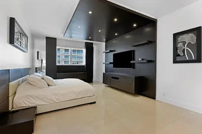 a bedroom with a bed and a flat screen tv at LUXURY PENTHOUSE ON THE BEACH 3/3 OCEANFRONT CONDO in Hollywood