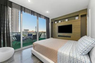 a bedroom with a bed and a balcony with a tv at LUXURY PENTHOUSE ON THE BEACH 3/3 OCEANFRONT CONDO in Hollywood