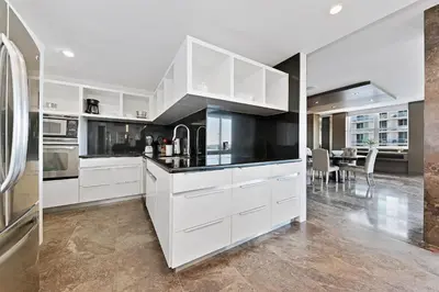 a kitchen with white cabinets and a dining room at LUXURY PENTHOUSE ON THE BEACH 3/3 OCEANFRONT CONDO in Hollywood