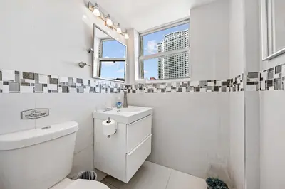 a bathroom with a toilet and a sink and a window at Oceanfront Luxury Penthouse On The Beach 3 Bedroom in Hollywood
