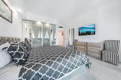 a bedroom with a black and white bed and a chair at Oceanfront Luxury Penthouse On The Beach 3 Bedroom in Hollywood