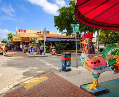 a statue of a chicken on a sidewalk next to a street at Villa Clara SUITE - Little Havana in Miami