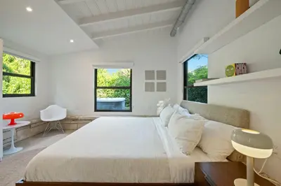 a bedroom with a large bed and two windows at Coconut Grove Mid-Century Jungle Oasis in Miami