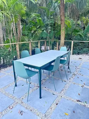 a blue table and chairs on a patio at Coconut Grove Mid-Century Jungle Oasis in Miami