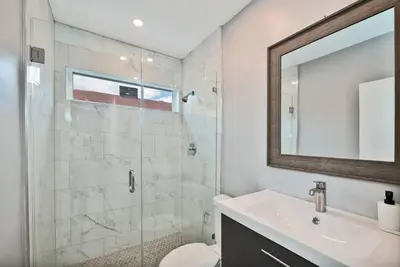 a bathroom with a shower and a sink and a mirror at Spacious 4 bedrooms, 2 bathroom house with pool in Miramar