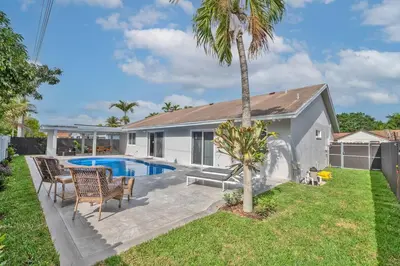 a house with a pool and a palm tree at Spacious 4 bedrooms, 2 bathroom house with pool in Miramar