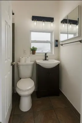 a bathroom with a toilet and a sink and a window at Modern Home - Termpurpedic Queen bed, Laundry, Free Parkging, EV Tesla in Hollywood