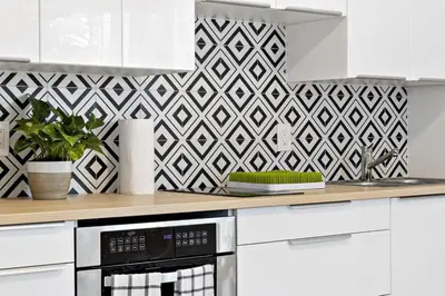 a kitchen with white cabinets and a geometric wallpaper at Lovely Studio with Great Location + Free Parking in Fort Lauderdale
