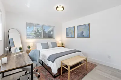 a white bedroom with a bed and a desk at Lovely Studio with Great Location + Free Parking in Fort Lauderdale