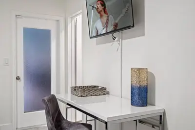 a room with a white table and a tv on the wall at Villa Oasis 3 Miles to Hard Rock Stadium & Casino, Guitar Hotel Nearby, Pool, Game Room, Sleeps 12, 15 Min to Beach in Pembroke Pines