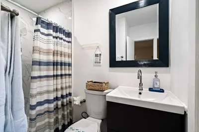 a bathroom with a sink and a toilet and a mirror at Villa Oasis 3 Miles to Hard Rock Stadium & Casino, Guitar Hotel Nearby, Pool, Game Room, Sleeps 12, 15 Min to Beach in Pembroke Pines