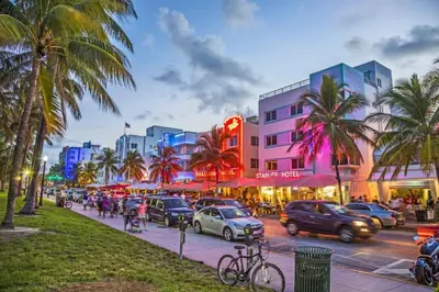 a busy city street with cars and people and palm trees at Villa Oasis 3 Miles to Hard Rock Stadium & Casino, Guitar Hotel Nearby, Pool, Game Room, Sleeps 12, 15 Min to Beach in Pembroke Pines