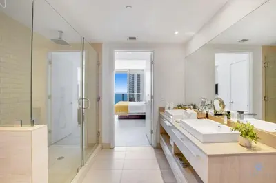 a bathroom with two sinks and a shower and a bedroom at Oceanfront Oasis, Luxury, Sunrise Views, Resort in Hollywood