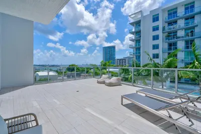 a balcony with chairs and a view of a building at 3900-719JC DESIGN DISTRICT, CONDO 1 BEDROOM /1 BATHROOM & BAYVIE in Miami