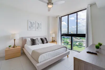 a white bedroom with a bed and a large window at 805MM DOWNTOWN DORAL CONDO 2 BEDROOMS & 2 BATHROOMS in Miami