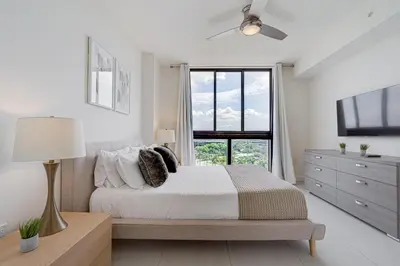 a white bedroom with a bed and a window at 805MM DOWNTOWN DORAL CONDO 2 BEDROOMS & 2 BATHROOMS in Miami