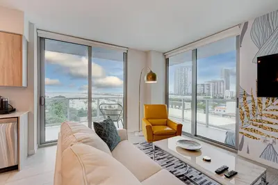 a living room with a white couch and large windows at 3900-717AS DESIGN DISTRICT, CONDO 2 BEDROOMS & 2 BATHROOMS & BAY in Miami