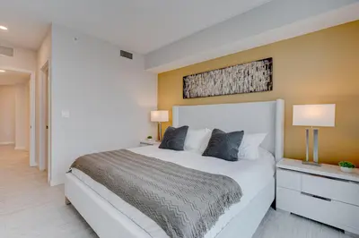 a bedroom with a large white bed with two lamps at 3900-717AS DESIGN DISTRICT, CONDO 2 BEDROOMS & 2 BATHROOMS & BAY in Miami